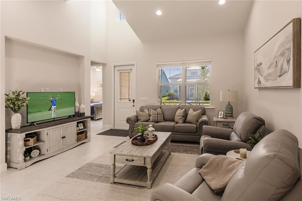 7263 Cayo Coco Lane Naples, FL 34113 - Photo 12 of 44 a living room with furniture a flat screen tv and a window