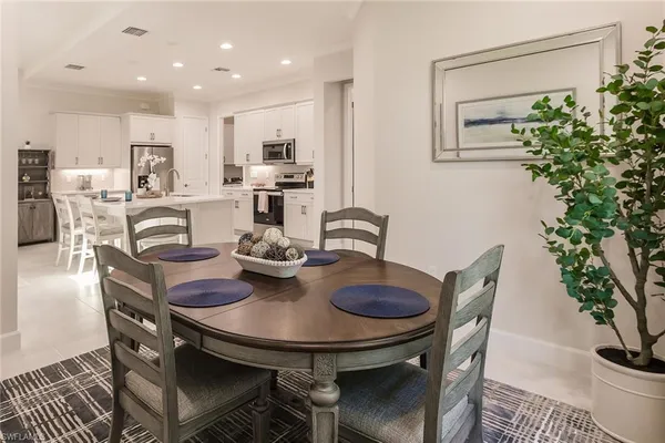 a view of a dining room and livingroom with furniture wooden floor and a potted plant