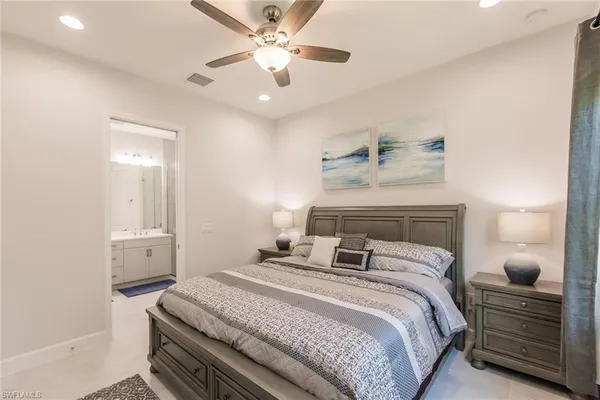 a bedroom with a large bed and a chandelier