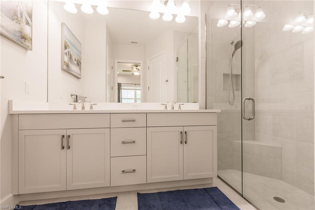 7263 Cayo Coco Lane Naples, FL 34113 - Photo 25 of 44 a bathroom with a shower sink and mirror