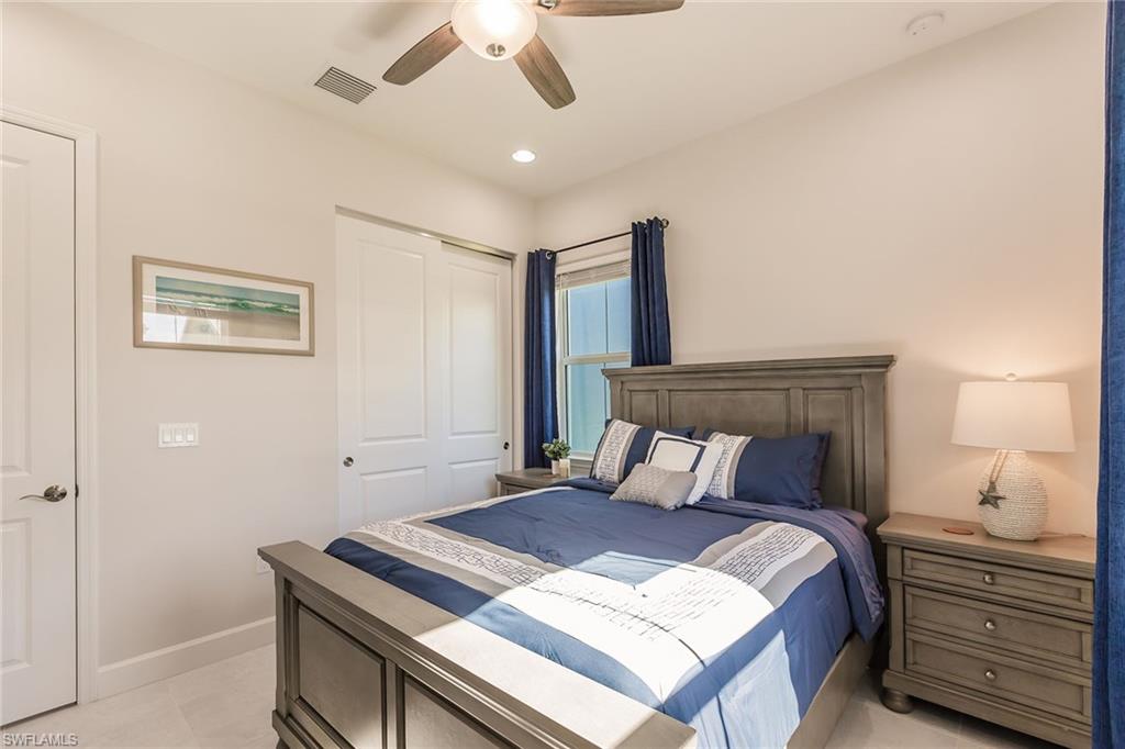7263 Cayo Coco Lane Naples, FL 34113 - Photo 27 of 44 a bedroom with a bed and a chandelier