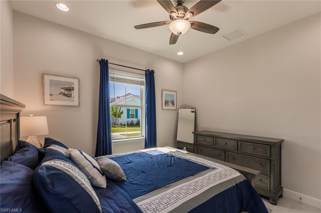 7263 Cayo Coco Lane Naples, FL 34113 - Photo 28 of 44 a bedroom with a bed and a chandelier