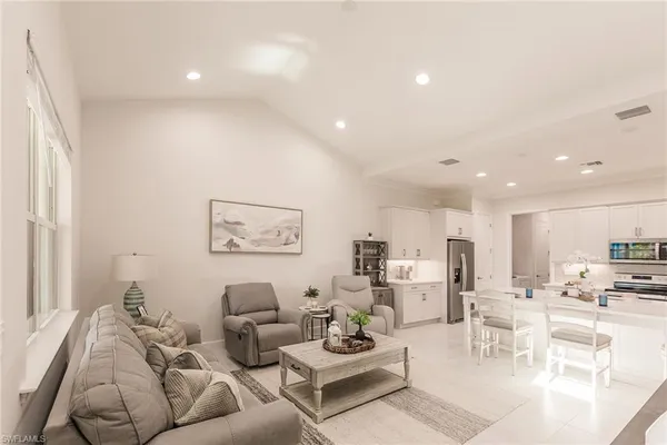 a living room with furniture and view of kitchen