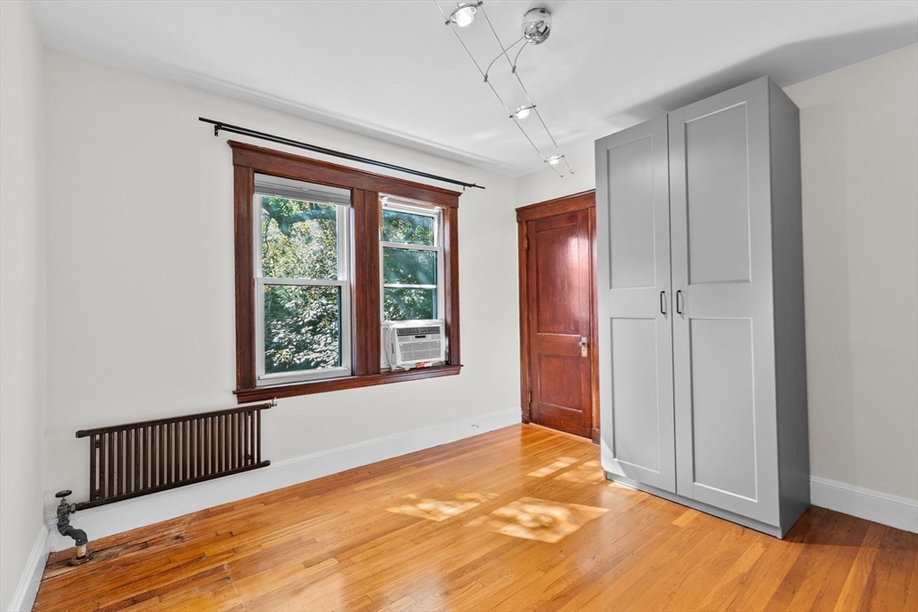 25 Whitby Terrace, Unit 3 Boston, MA 02125 - Photo 25 of 35 a view of an empty room with a window and wooden floor