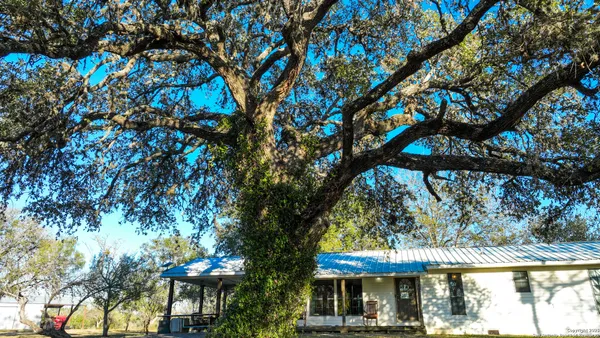 a view of patio with a table and chairs under an umbrella