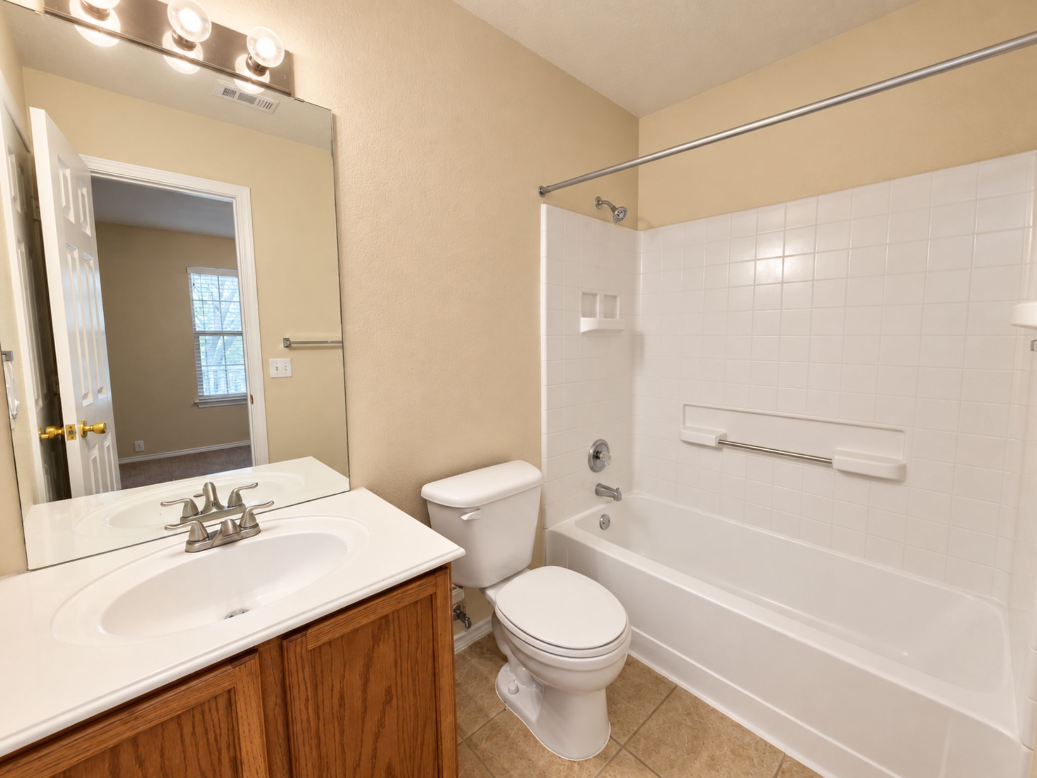 5679 Fergus, Unit B Kyle, TX 78640 - Photo 21 of 26 A classic bathtub and tile surround complement the wooden vanity in this bathroom.
