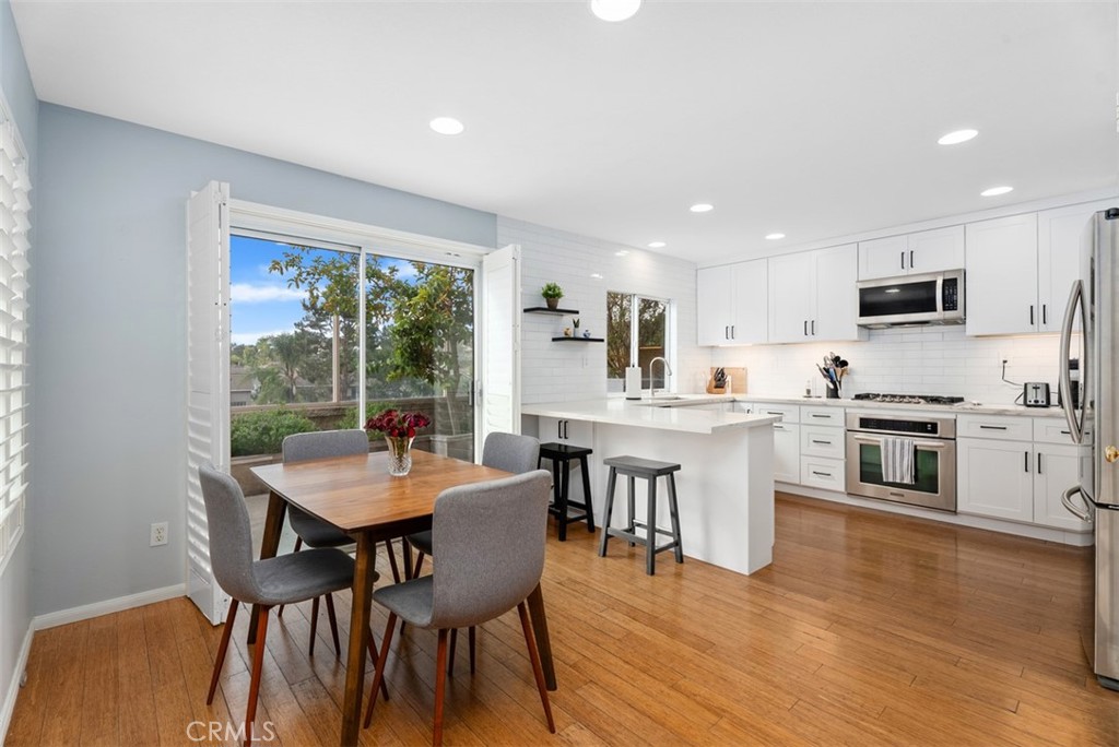 26 Richemont Way Aliso Viejo, CA 92656 - Photo 1 of 33 a kitchen with white cabinets a table and chairs in it