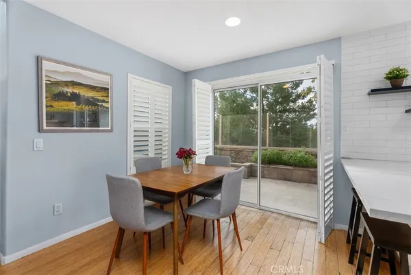 a kitchen with stainless steel appliances a sink a stove a refrigerator cabinets and a dining table