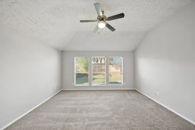 an empty room with closet and windows