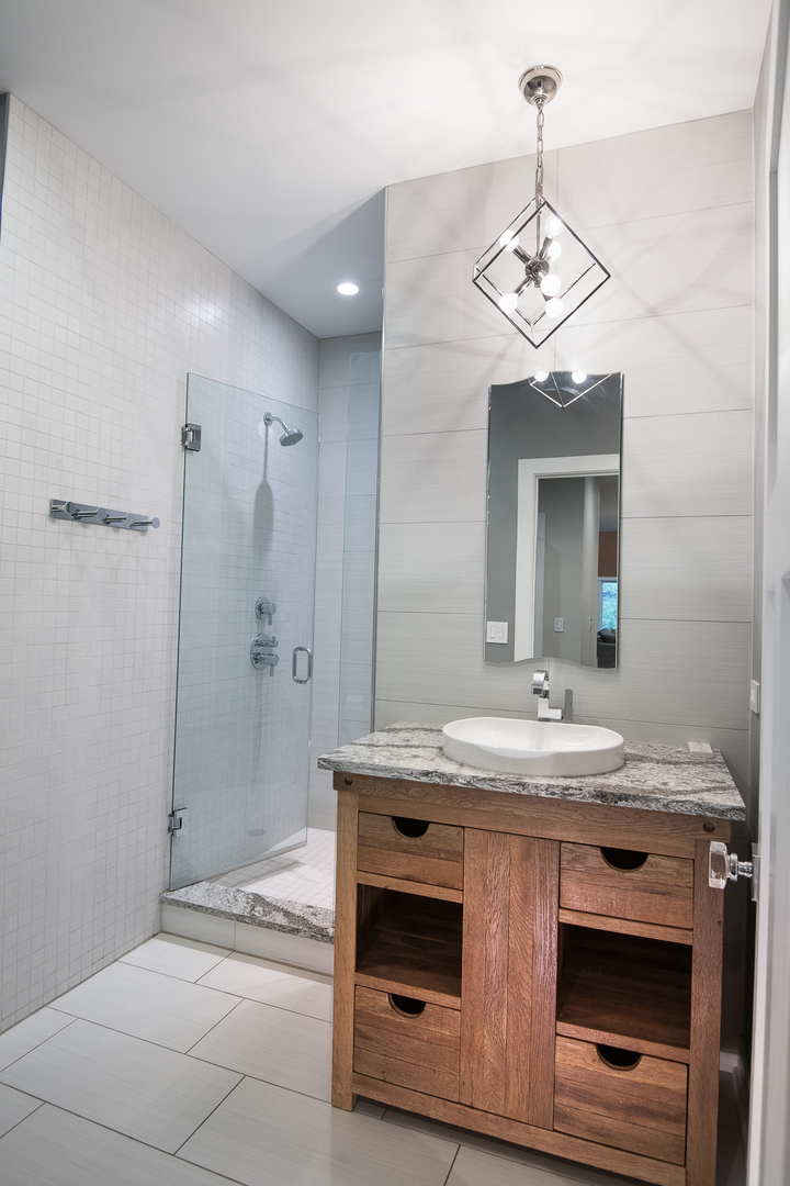 Undisclosed Address Riverwoods, IL 60015 - Photo 16 of 33 a bathroom with a sink a large mirror and shower