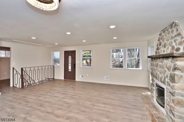 a view of an empty room with a fireplace and a window