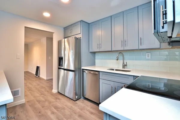 a kitchen with stainless steel appliances granite countertop a refrigerator a stove and a sink with granite countertops