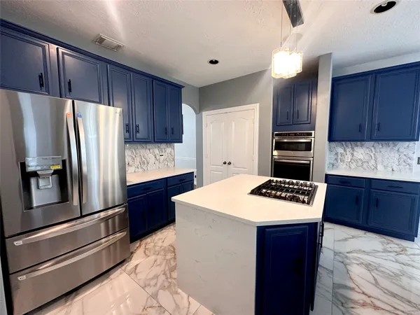 a kitchen with stainless steel appliances wooden cabinets a refrigerator and a stove