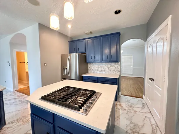 a kitchen with wooden floor and stainless steel appliances
