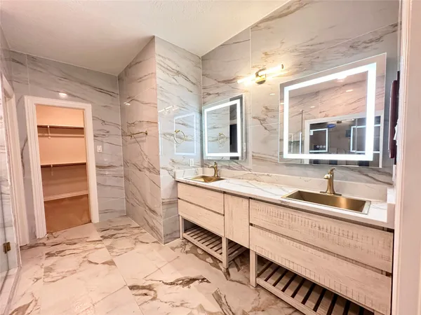 a large bathroom with a sink mirror and a bath tub