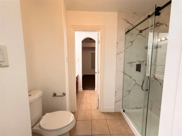 a bathroom with a granite countertop shower a toilet and a shower