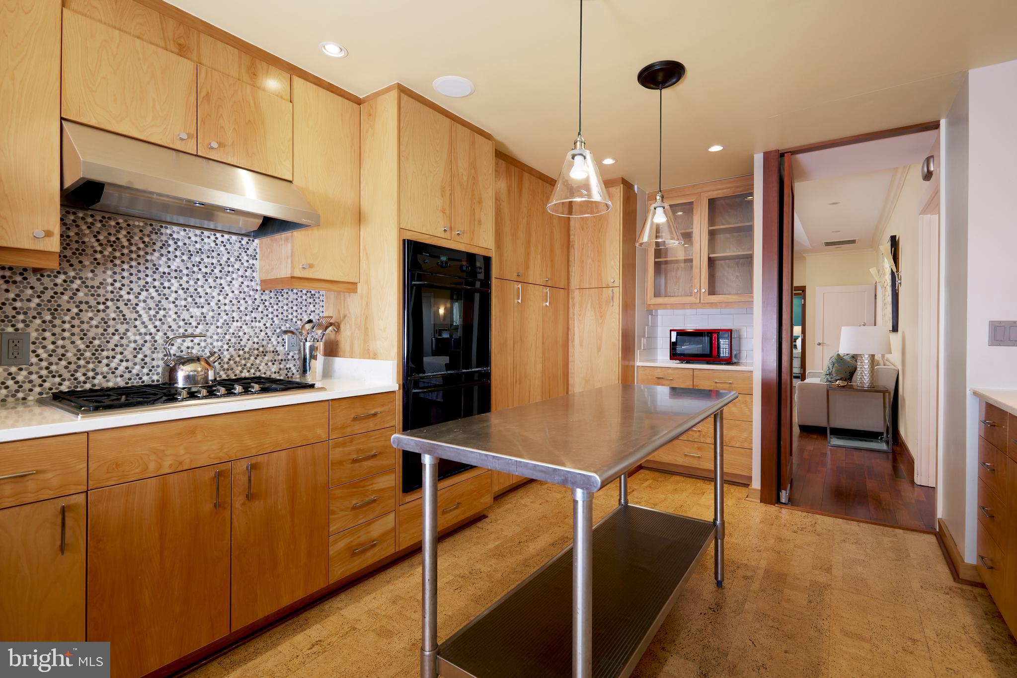 2230 California Street Northwest, Unit 6AE Washington, DC 20008 - Photo 11 of 45 a kitchen with stainless steel appliances kitchen island granite countertop a refrigerator a stove and white cabinets with wooden floor