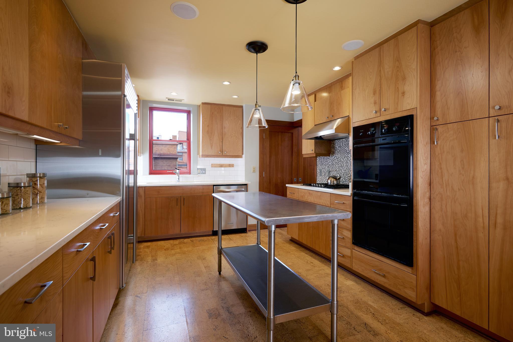 2230 California Street Northwest, Unit 6AE Washington, DC 20008 - Photo 12 of 45 a kitchen with kitchen island a counter space a sink a refrigerator and a stove