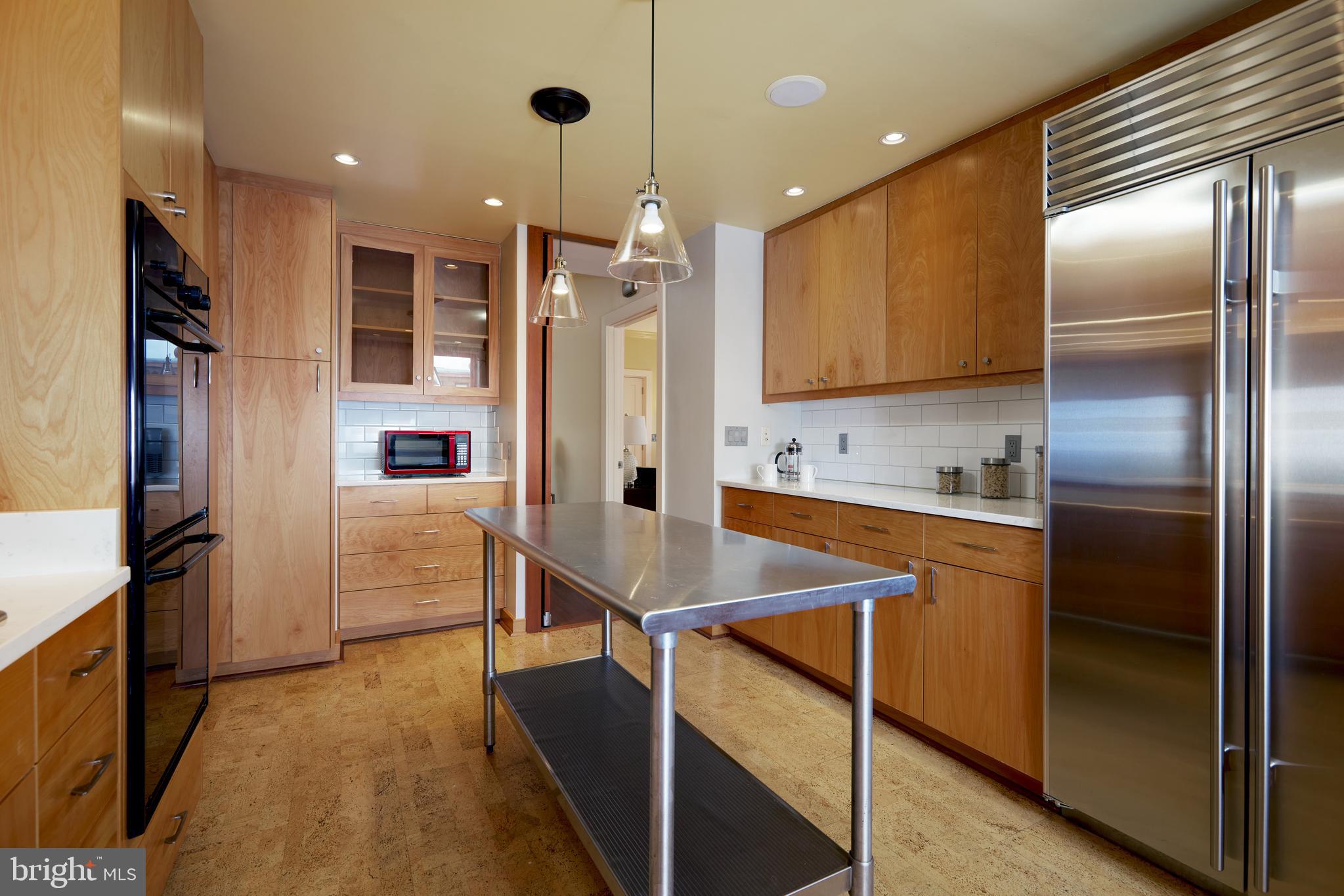 2230 California Street Northwest, Unit 6AE Washington, DC 20008 - Photo 10 of 45 a kitchen with stainless steel appliances kitchen island granite countertop a refrigerator and a sink