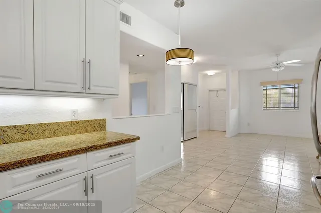 a kitchen with granite countertop a sink a refrigerator and cabinets