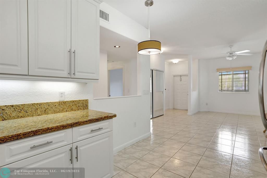 7727 Southampton Terrace, Unit 205 Tamarac, FL 33321 - Photo 17 of 36 a kitchen with granite countertop a sink a refrigerator and cabinets