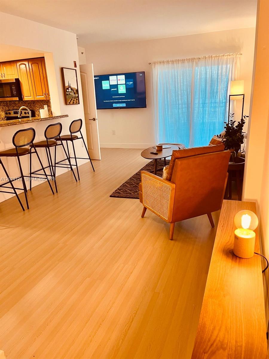 120 South Douglas Road, Unit 302 Miami, FL 33134 - Photo 3 of 28 a living room with furniture and a flat screen tv