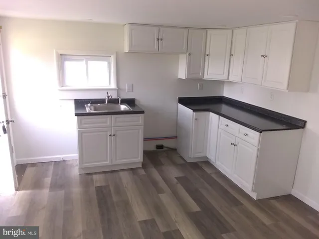 a kitchen with granite countertop white cabinets and white appliances