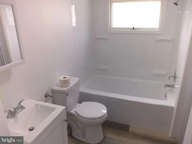 a white toilet sitting next to a bath tub