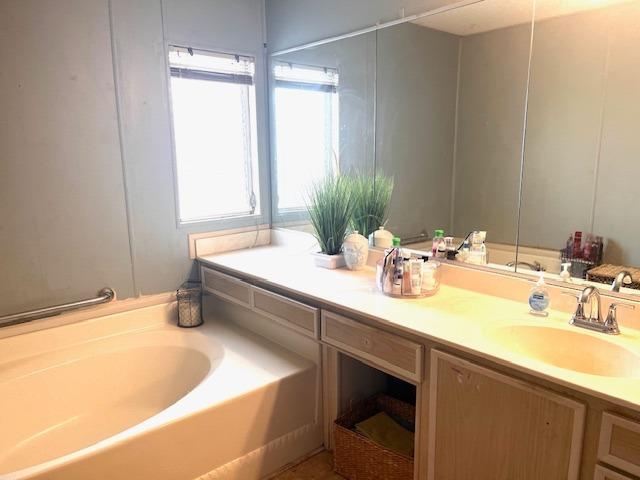 2706 West Ashlan Avenue, Unit 329 Fresno, CA 93705 - Photo 21 of 43 a bathroom with a tub sink and mirror