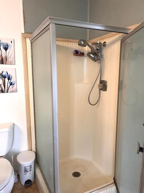 2706 West Ashlan Avenue, Unit 329 Fresno, CA 93705 - Photo 22 of 43 a bathroom with a shower a toilet and a glass door