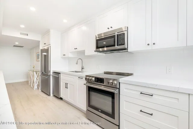 a kitchen with a dining table chairs and white cabinets