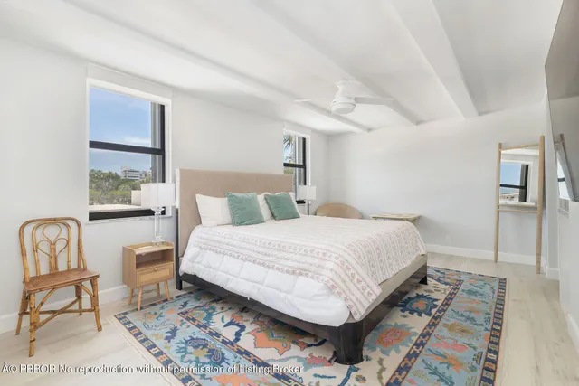 a spacious bedroom with a bed and a flat screen tv