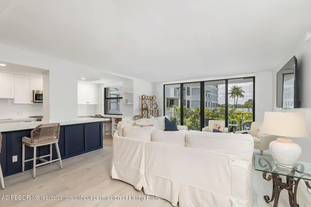 a large white kitchen with a large window and stainless steel appliances