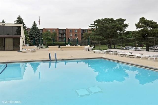 1615 East Central Road, Unit 417C Arlington Heights, IL 60005 - Photo 19 of 23 a view of a swimming pool with a lawn chairs