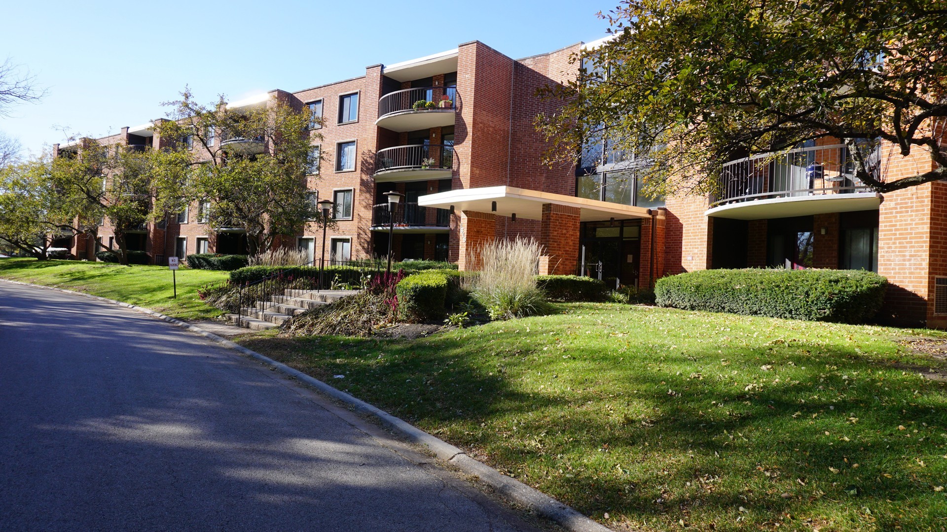 1615 East Central Road, Unit 417C Arlington Heights, IL 60005 - Photo 22 of 23 a view of a house with a yard and large tree