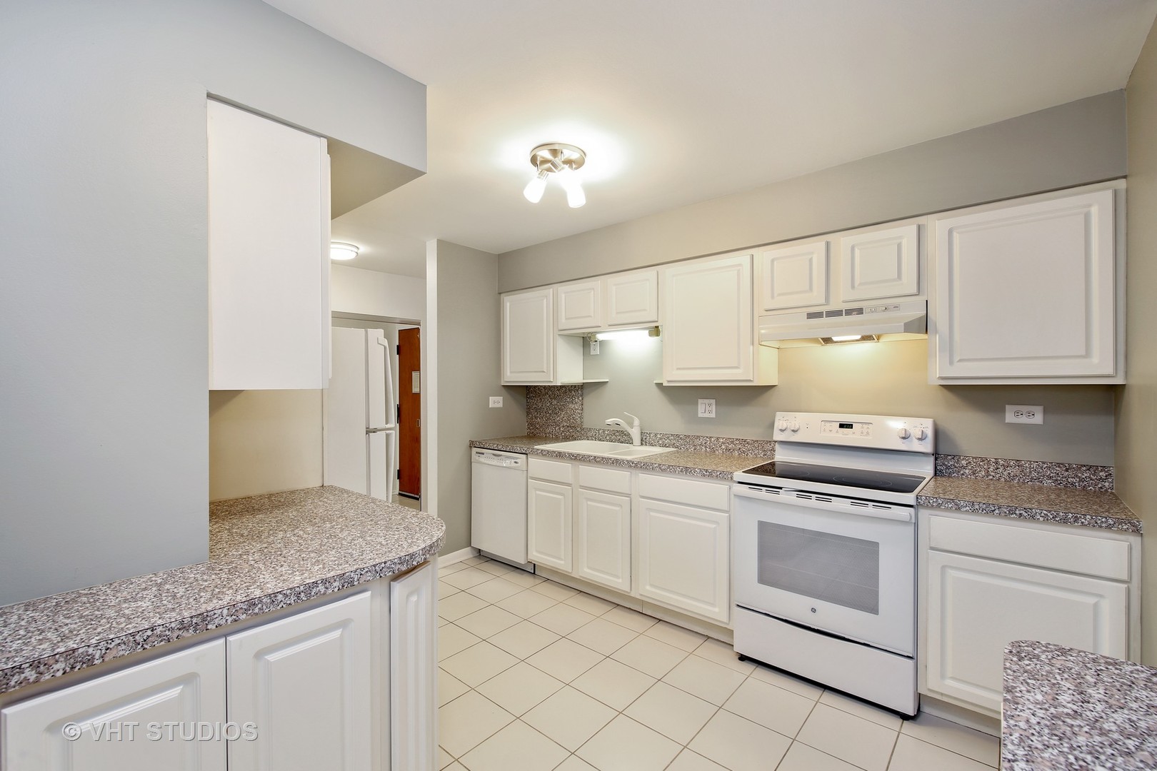 1615 East Central Road, Unit 417C Arlington Heights, IL 60005 - Photo 8 of 23 a kitchen with granite countertop white cabinets and white appliances