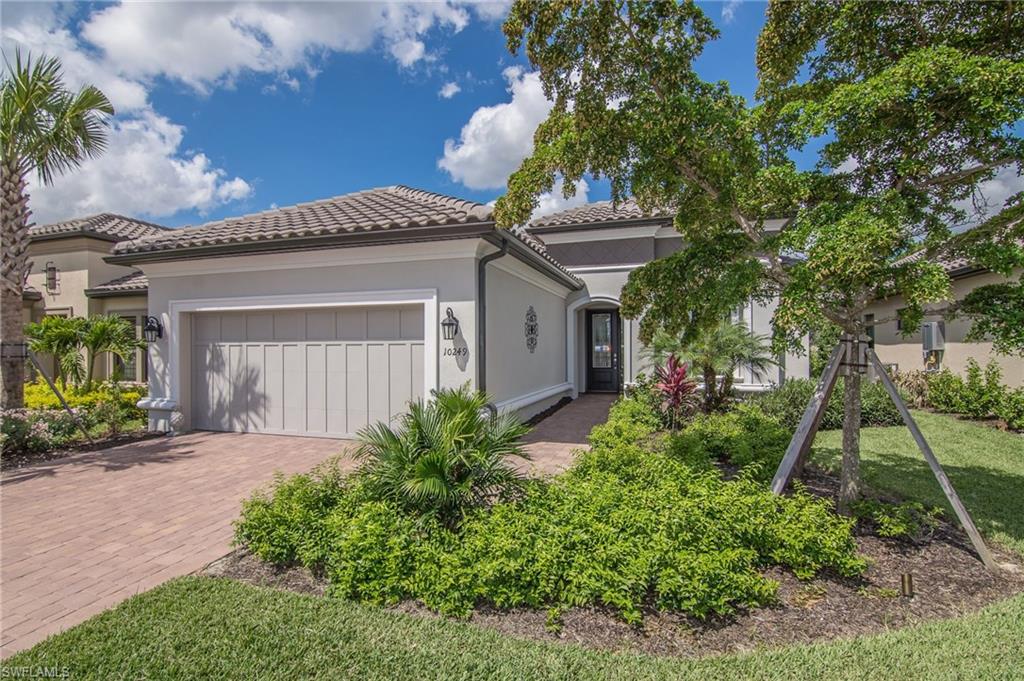 10249 Coconut Road Estero, FL 34135 - Photo 3 of 27 a front view of a house with a yard