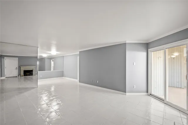 an empty room with windows and fireplace