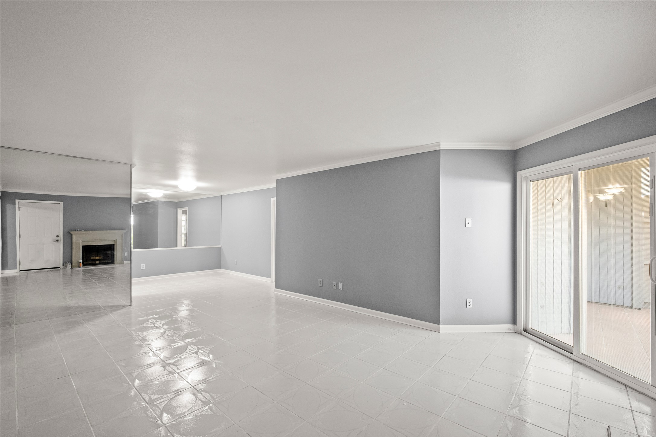 an empty room with windows and fireplace