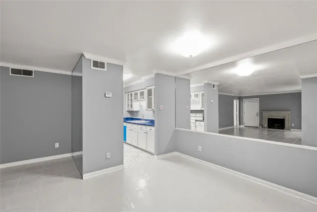 a view of an empty room with a fireplace and windows