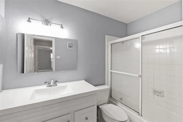 a bathroom with a sink toilet vanity and shower