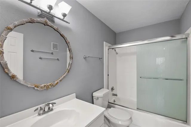 a bathroom with a sink and mirror with toilet