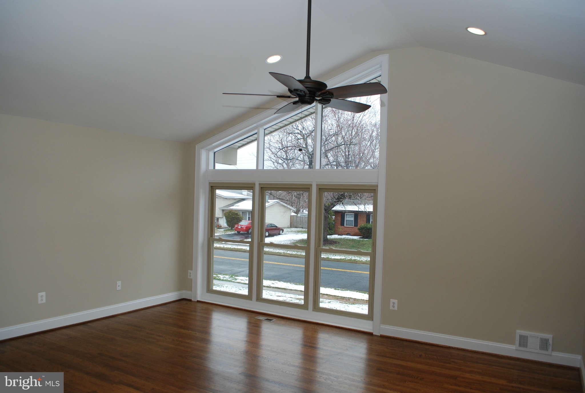 6020 Frontier Drive Springfield, VA 22150 - Photo 5 of 12 a view of an empty room with wooden floor a ceiling fan and a window
