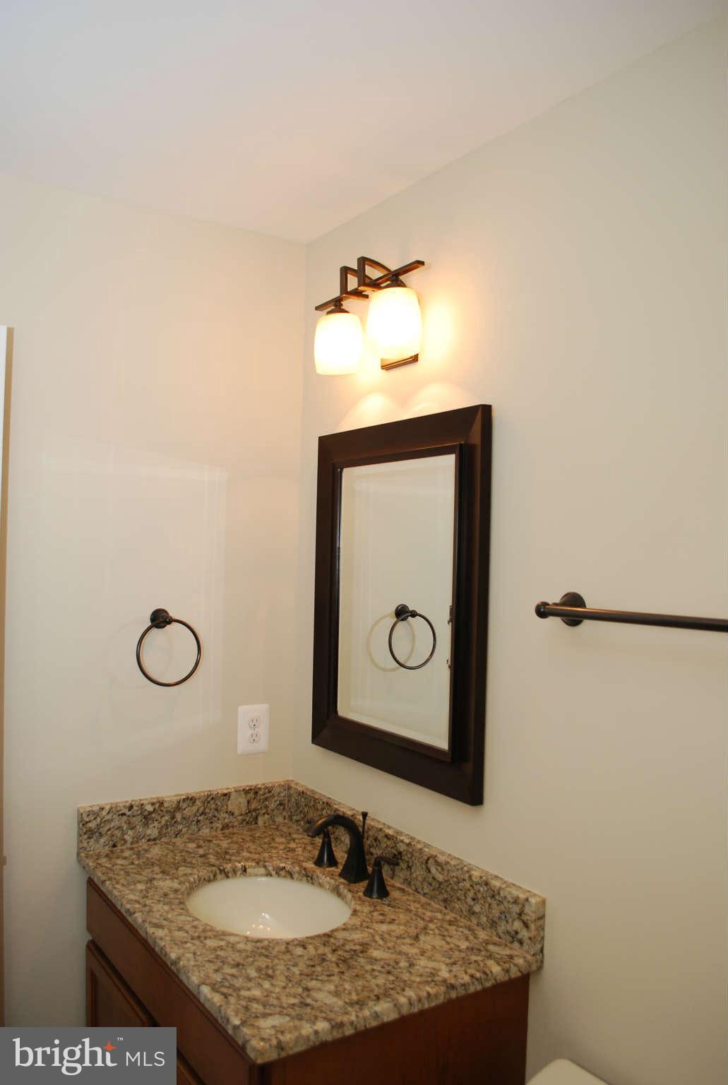 6020 Frontier Drive Springfield, VA 22150 - Photo 8 of 12 a bathroom with a granite countertop sink and mirror