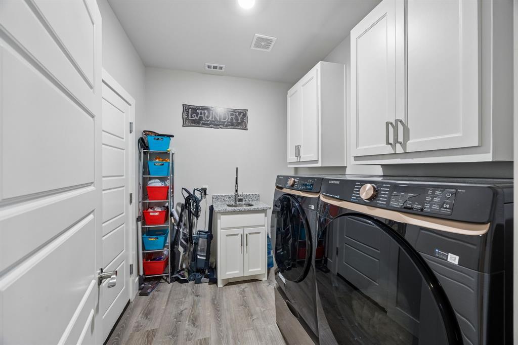 612 Frisco Road Sherman, TX 75090 - Photo 7 of 25 Dedicated laundry area featuring wood-finish flooring, white cabinetry with silver hardware, and a utility sink with a granite-look countertop