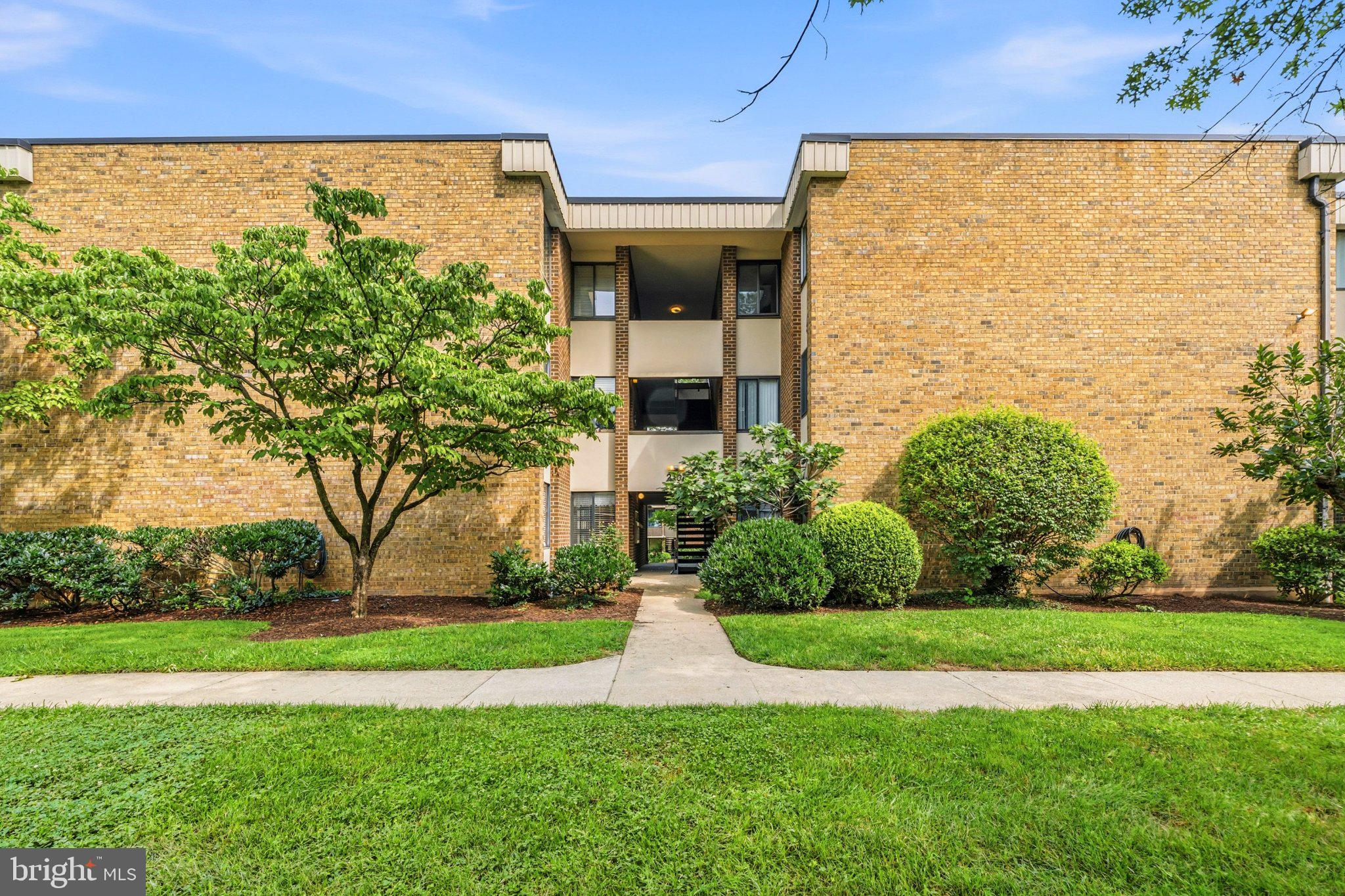 2103 Walsh View Terrace, Unit 102 Silver Spring, MD 20902 - Photo 1 of 30 Charming brick facade with lush greenery.
