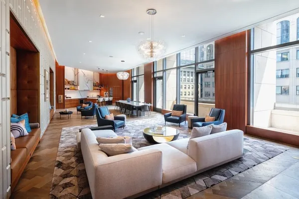 a living room with furniture kitchen view and a large window