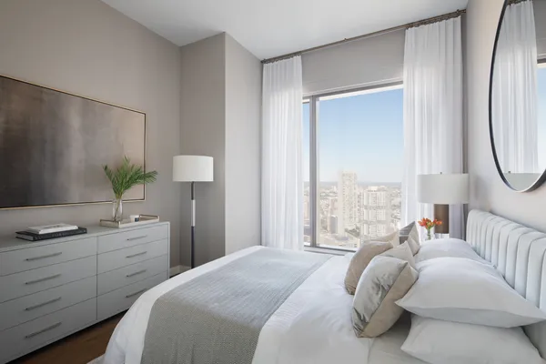 a bedroom with a bed potted plant with the mirror