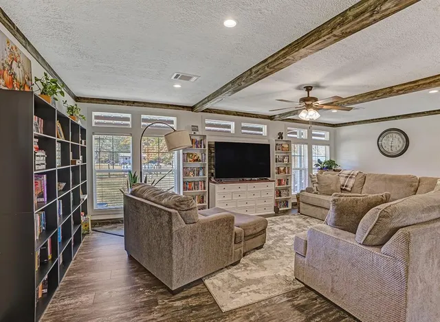 a spacious bedroom with a bed couch and a flat tv screen