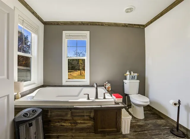 a spacious bedroom with a bed a couch and a chandelier